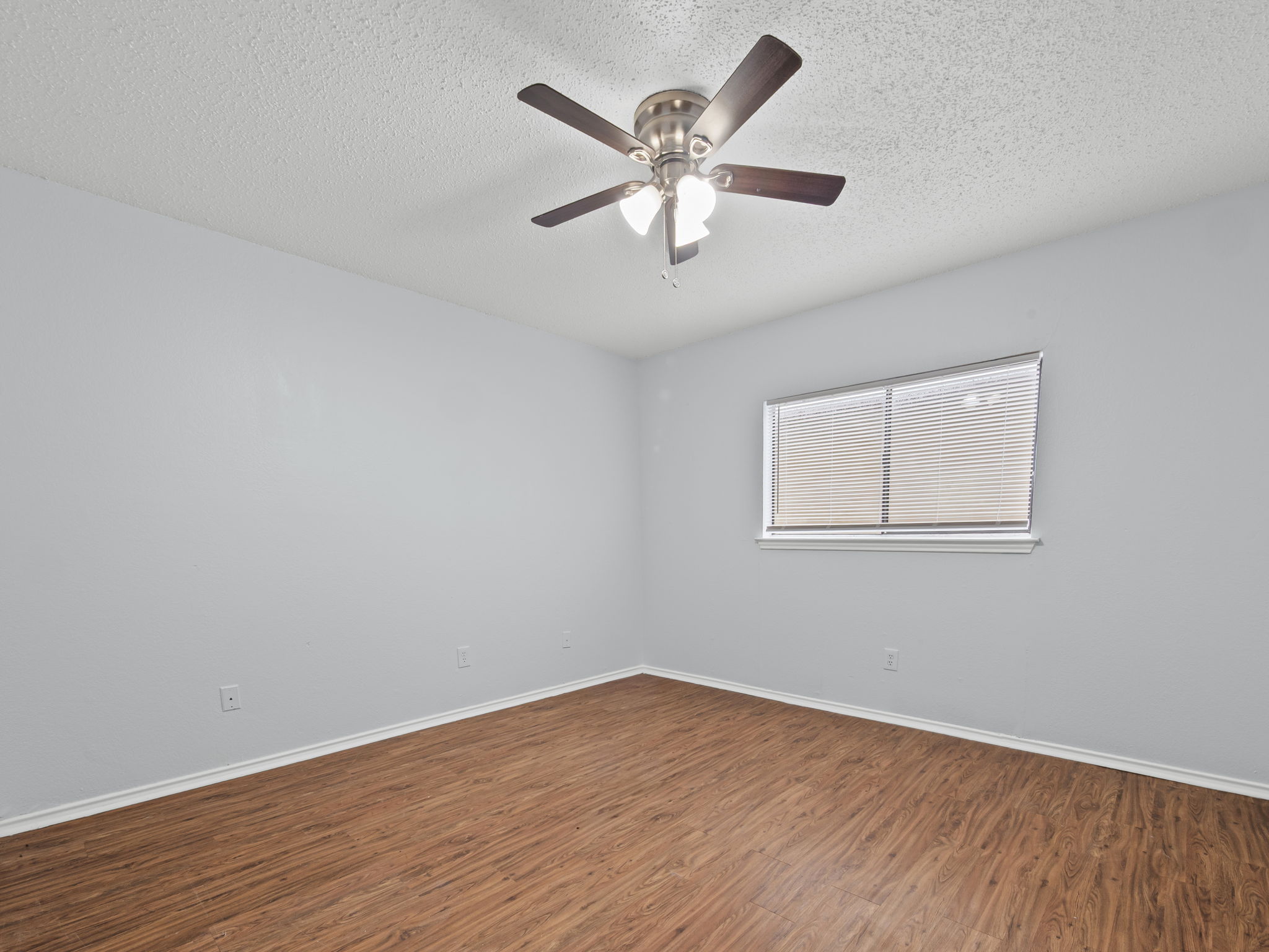 1816 Rawhide Loop, Unit 1822 Round Rock, TX 78681 - Photo 10 of 17 Empty room with wood finished floors, a ceiling fan, and a textured ceiling