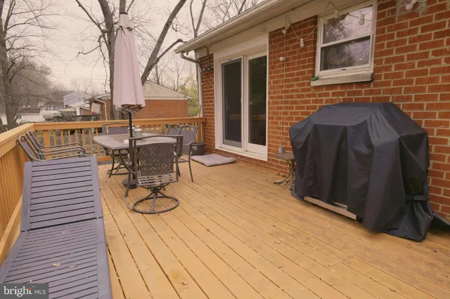 a view of a patio with table and chairs with wooden floor and fence