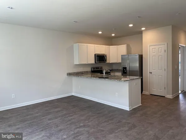 a open kitchen with white cabinets and stainless steel appliances