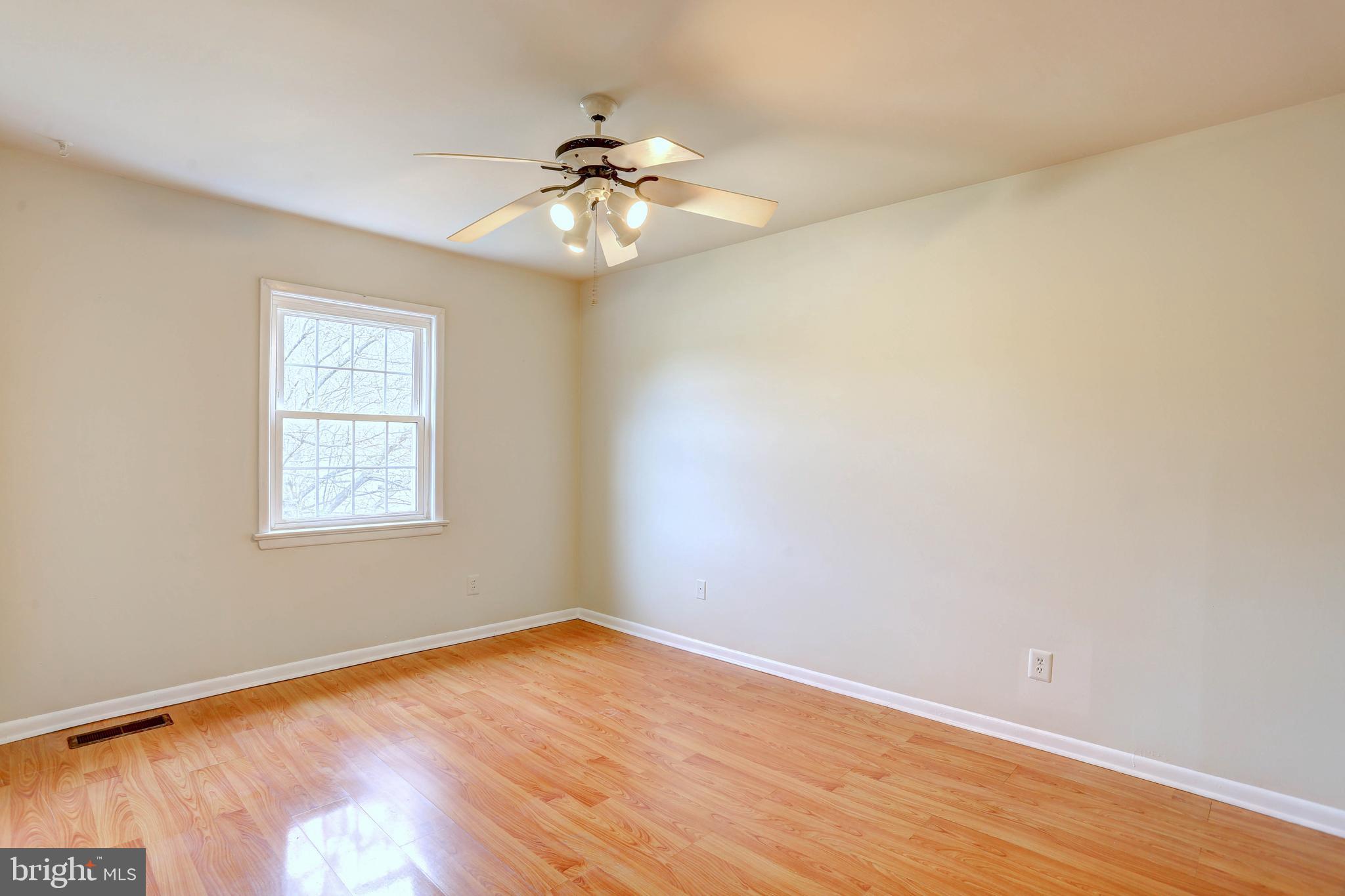 9110 Tumbleweed Run, Unit G Laurel, MD 20723 - Photo 14 of 32 a view of an empty room with wooden floor and a window