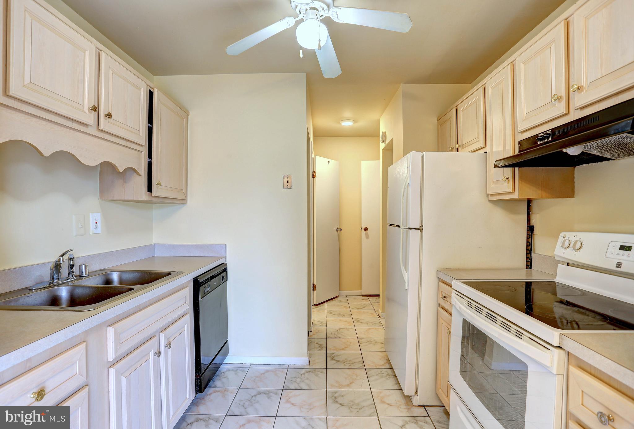 9110 Tumbleweed Run, Unit G Laurel, MD 20723 - Photo 7 of 32 a kitchen with stainless steel appliances granite countertop a sink stove and refrigerator