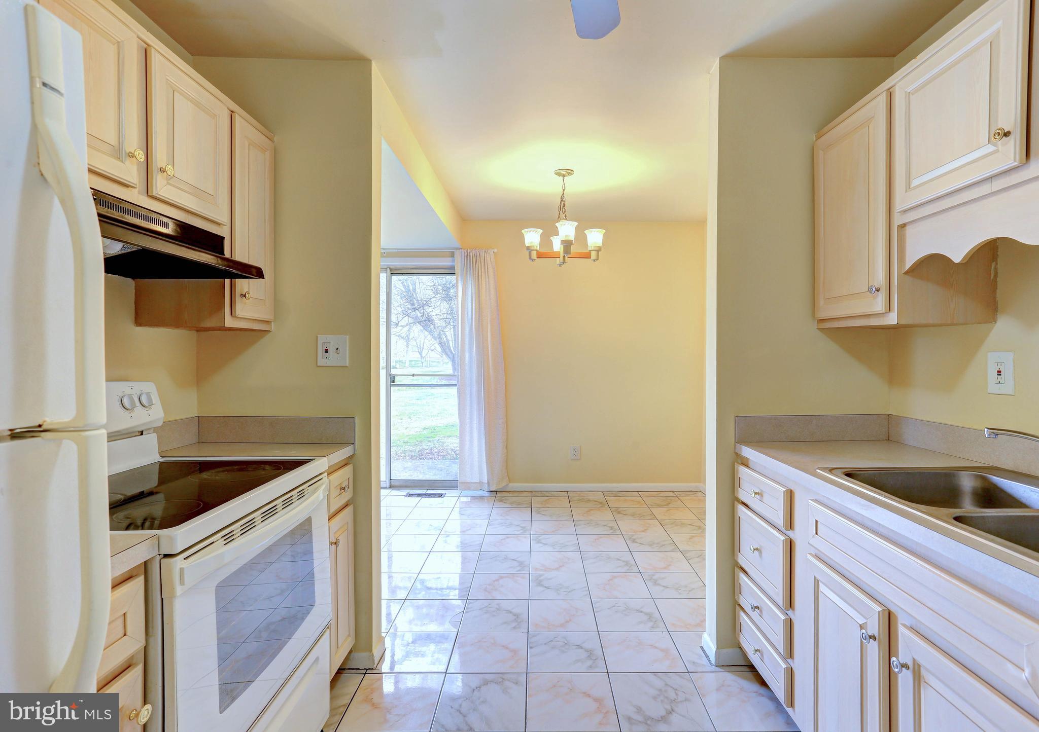 9110 Tumbleweed Run, Unit G Laurel, MD 20723 - Photo 8 of 32 a kitchen with granite countertop a sink and a stove