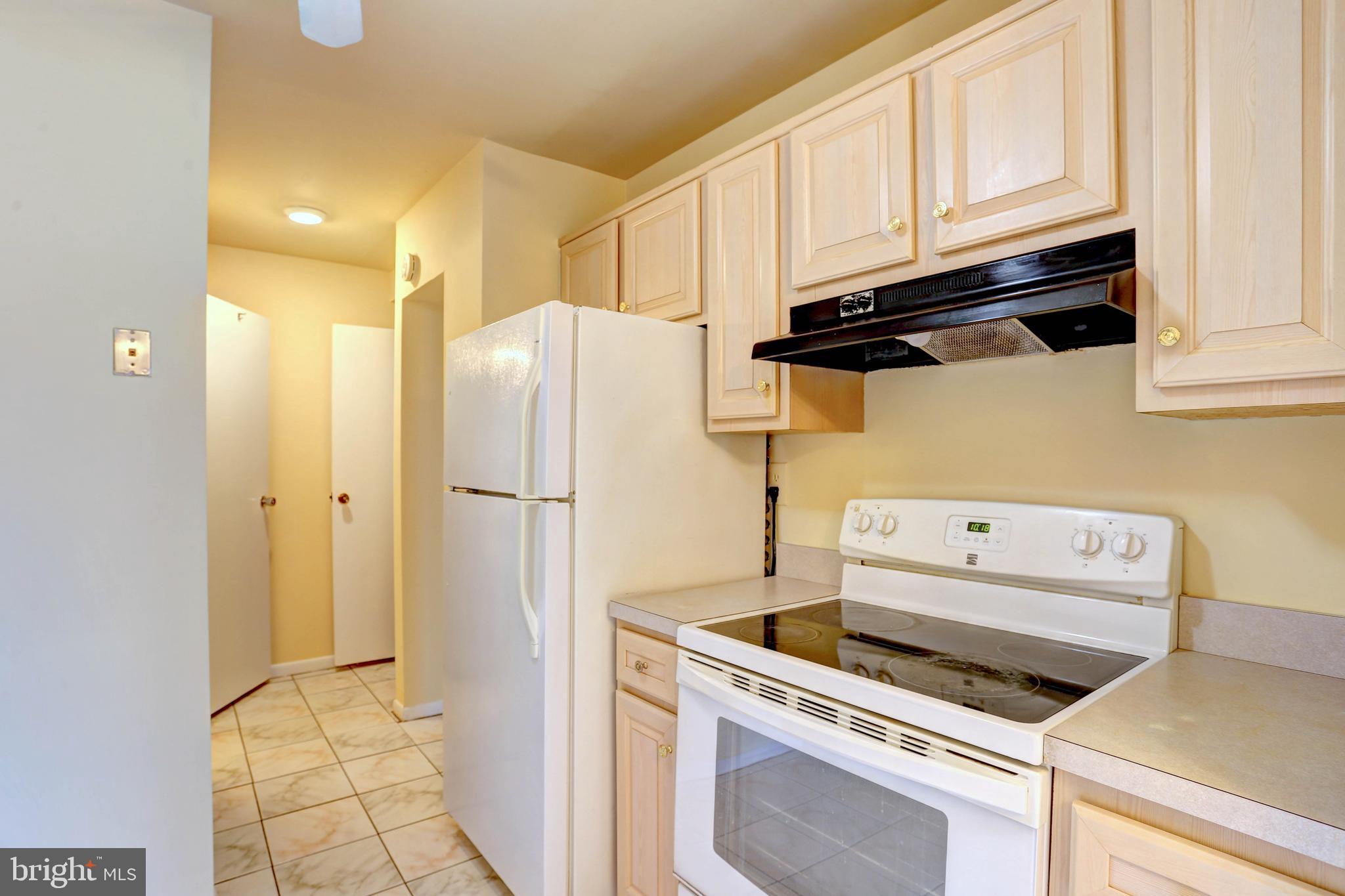 9110 Tumbleweed Run, Unit G Laurel, MD 20723 - Photo 10 of 32 a kitchen with a refrigerator and cabinets