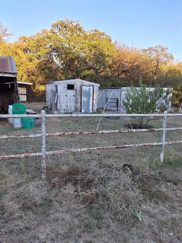 a view of a yard with wooden fence