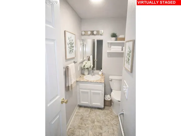 a bathroom with a granite countertop toilet a sink and a mirror