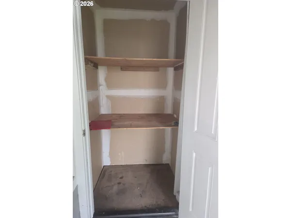 a view of a room with wooden floor and a window