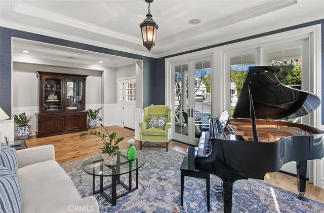 a living room with furniture a chandelier and a flat screen tv