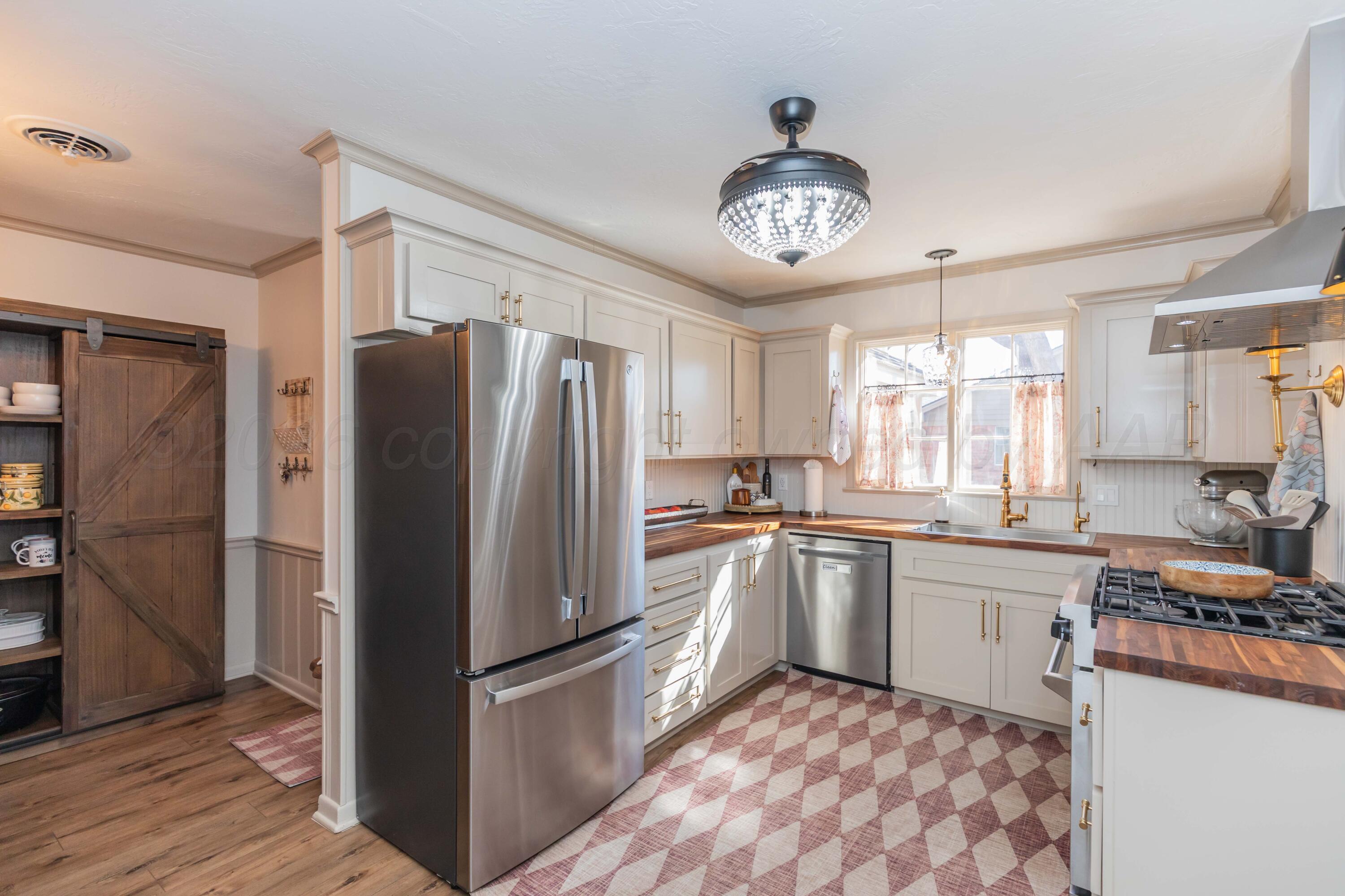 6308 Jameson Road Amarillo, TX 79106 - Photo 11 of 43 a kitchen with stainless steel appliances granite countertop a refrigerator a sink a stove and island