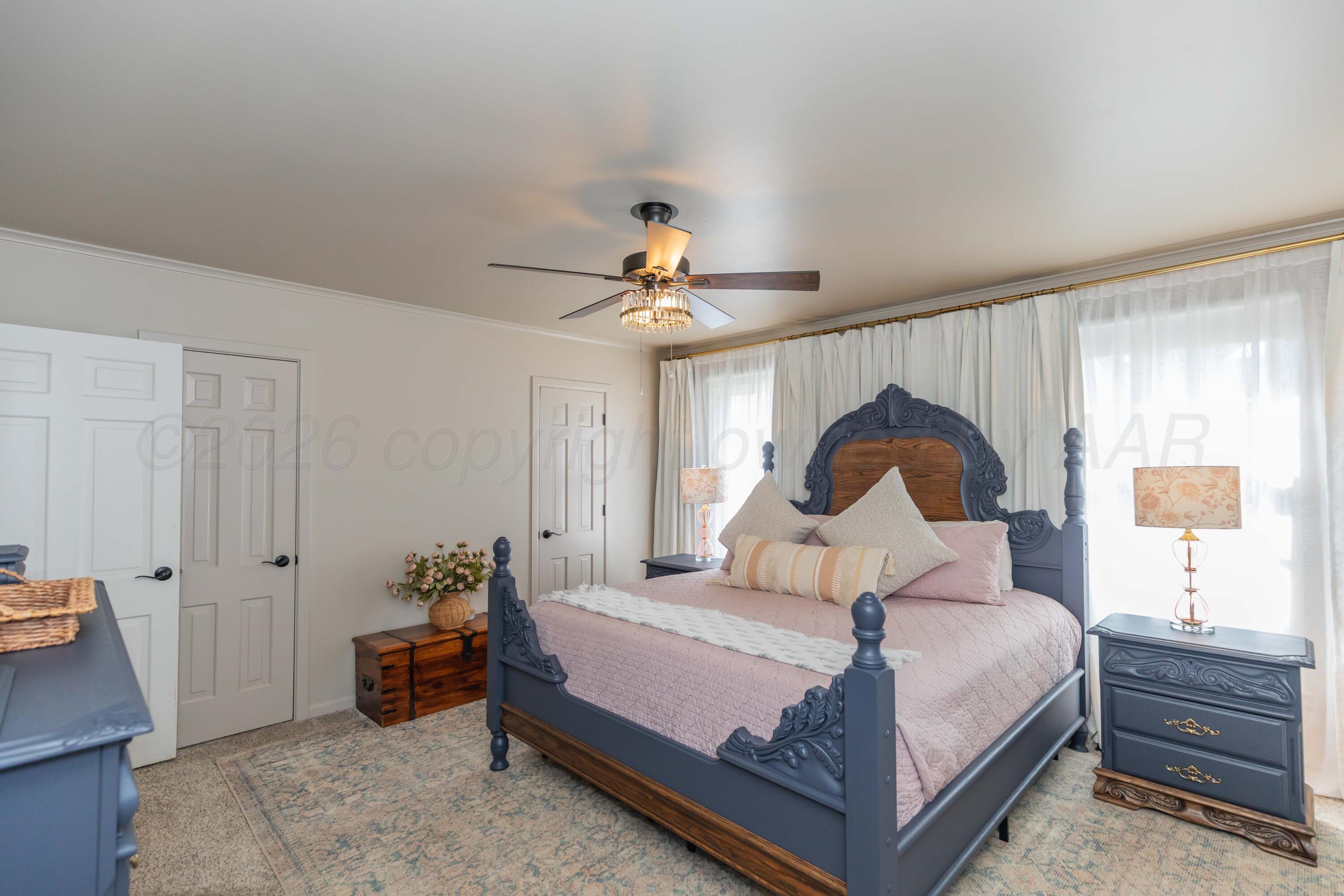 6308 Jameson Road Amarillo, TX 79106 - Photo 32 of 43 a bedroom with a bed and a chandelier