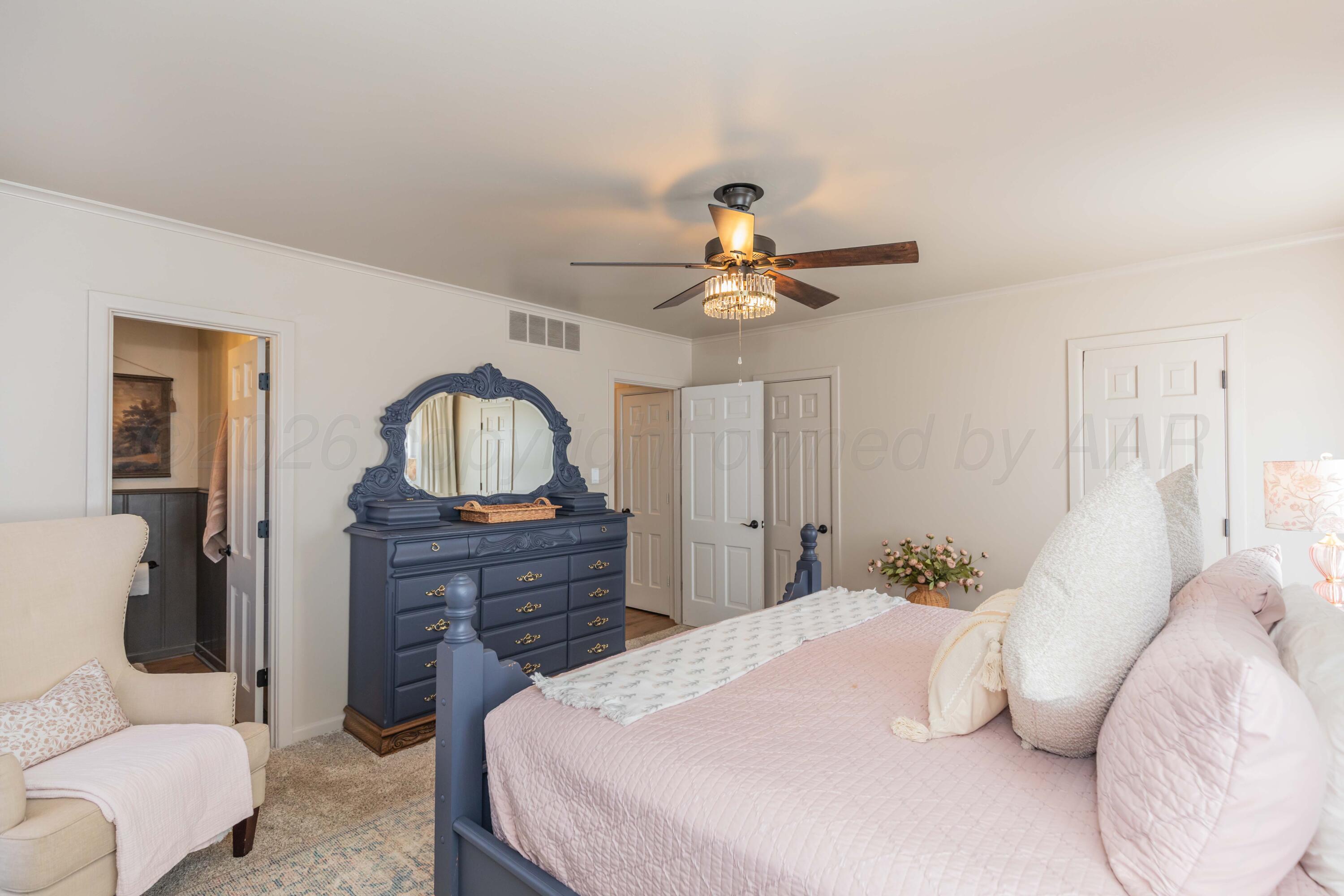 6308 Jameson Road Amarillo, TX 79106 - Photo 33 of 43 a bedroom with a bed and a chandelier