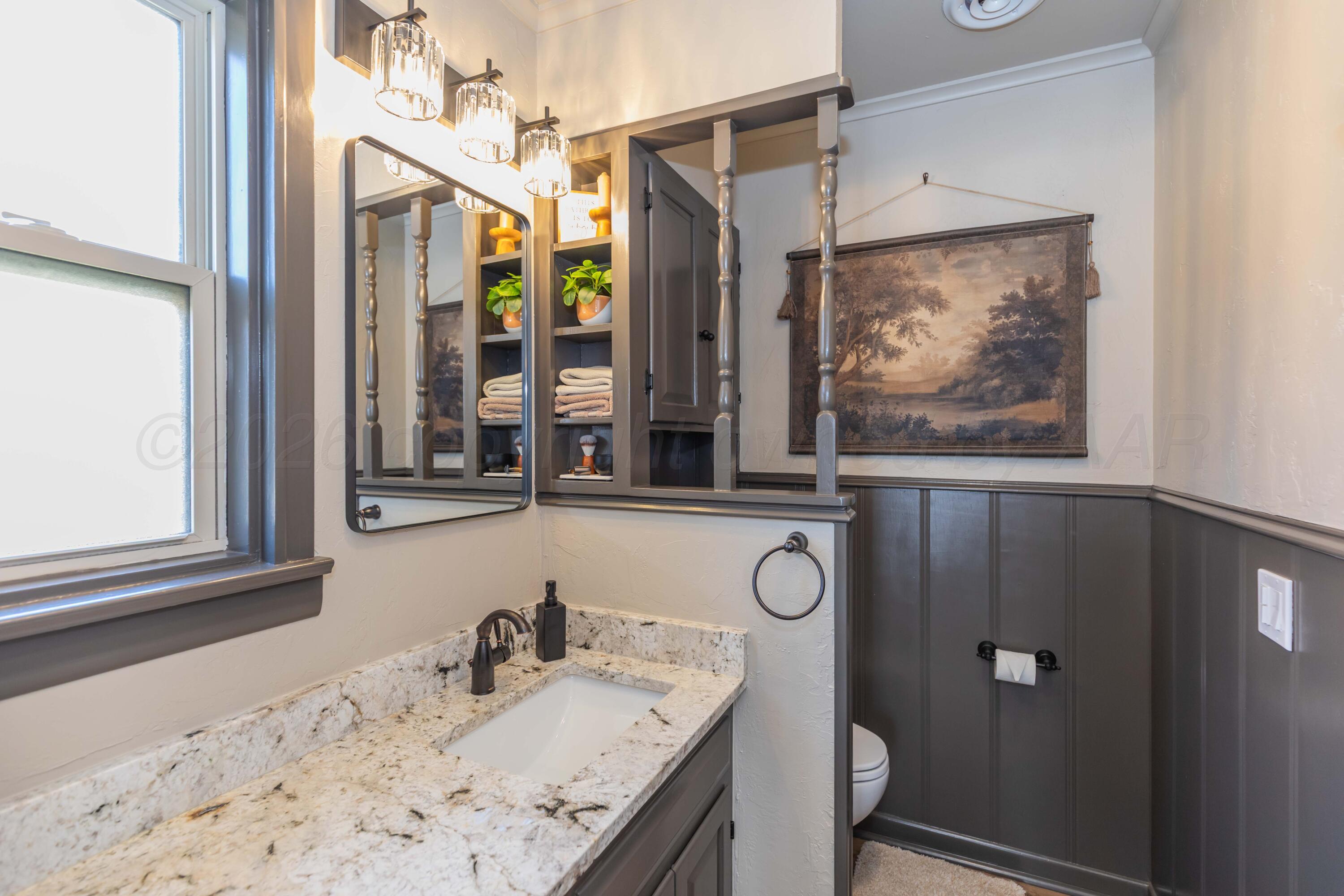 6308 Jameson Road Amarillo, TX 79106 - Photo 35 of 43 a bathroom with a granite countertop sink a mirror and shower