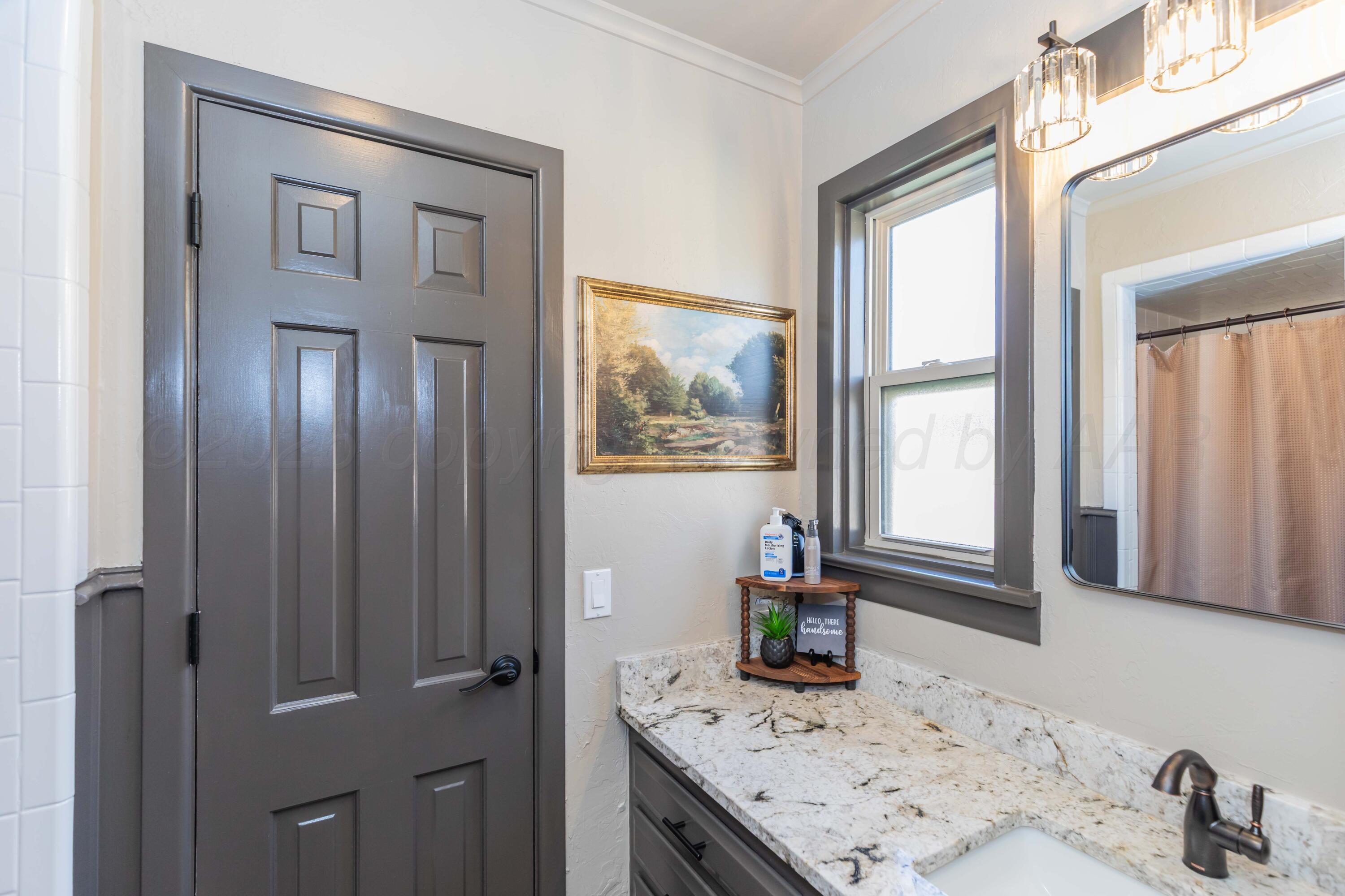 6308 Jameson Road Amarillo, TX 79106 - Photo 36 of 43 a bathroom with a granite countertop sink and a window