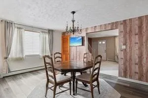 a dining room with furniture window and wooden floor