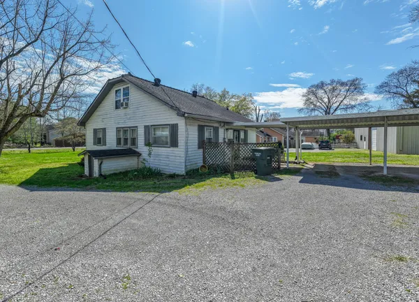 a front view of a house with a yard and trees