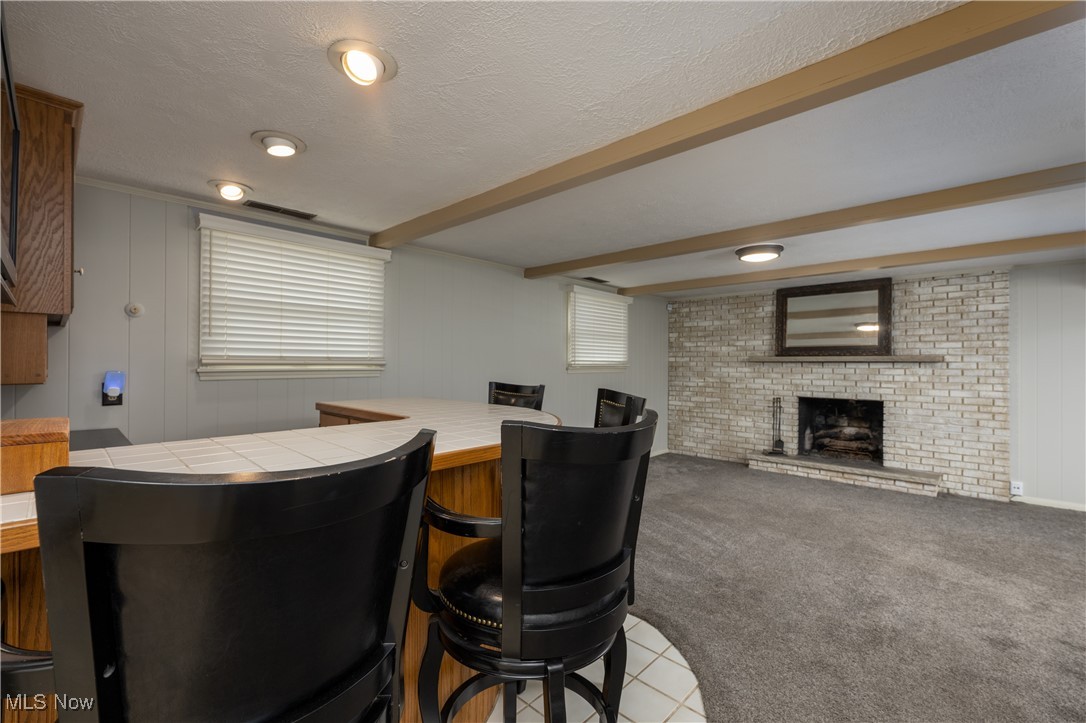 3721 20th Street Northwest Canton, OH 44708 - Photo 20 of 47 Carpeted dining area with a fireplace, bar, beam ceiling, and a textured ceiling