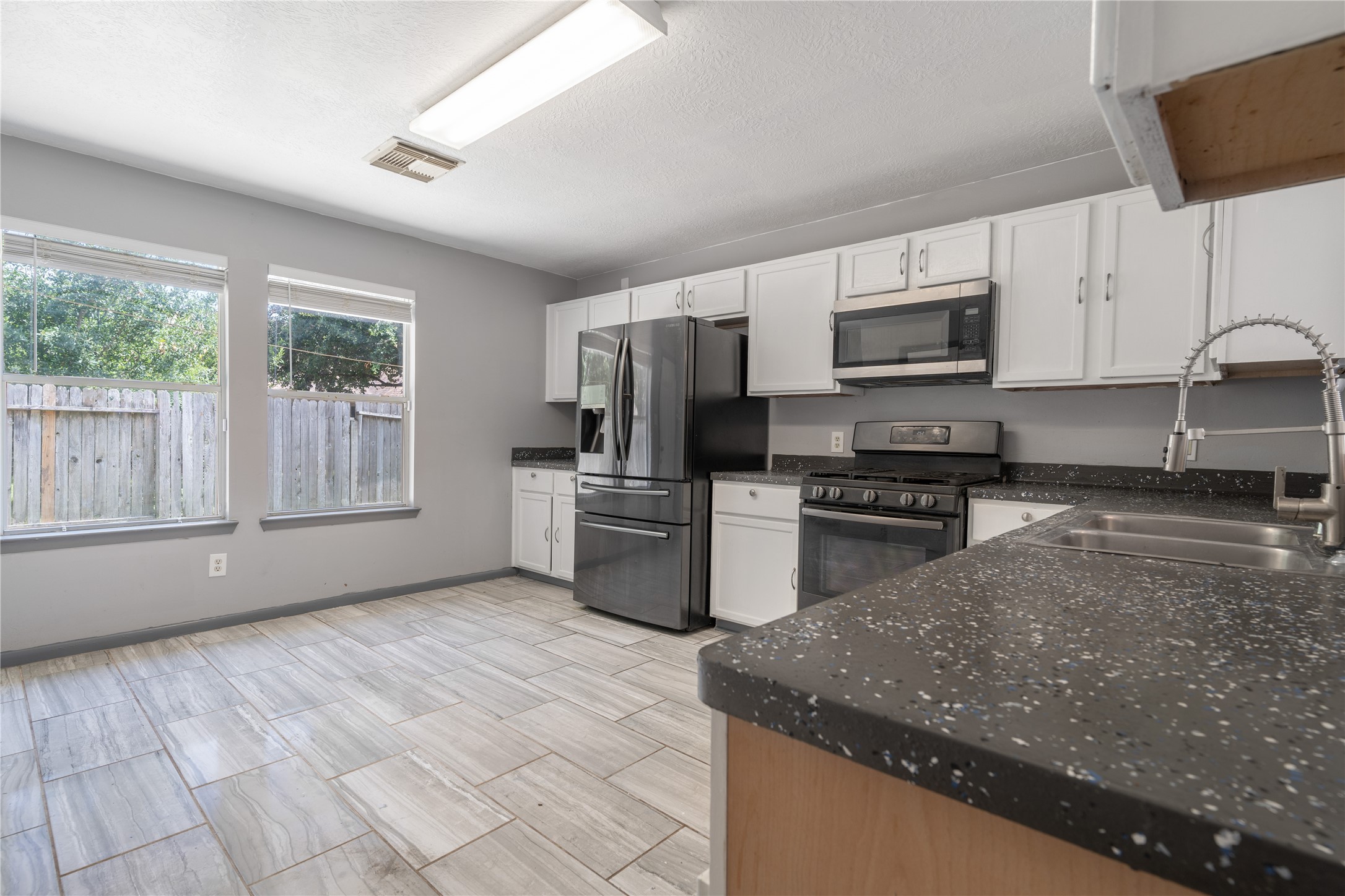 19431 River Bottom Road Katy, TX 77449 - Photo 5 of 12 a kitchen with stainless steel appliances granite countertop a sink a stove a microwave and cabinets