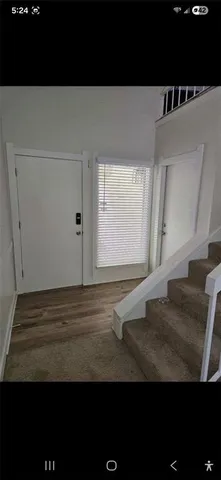 a view of a livingroom with an empty space & a window