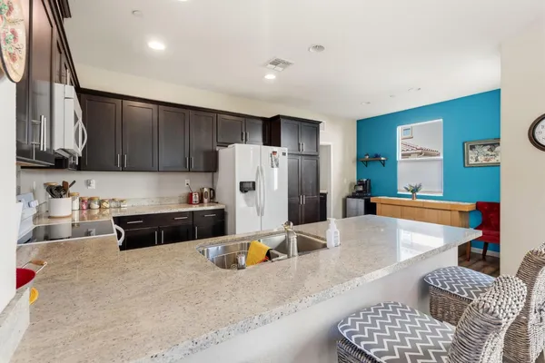 a kitchen with a refrigerator and a stove top oven