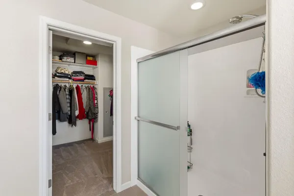 a view of walk in closet with clothes and shoes