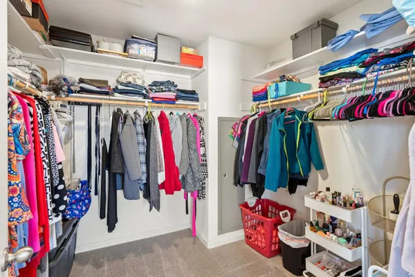 a view of walk in closet with clothes