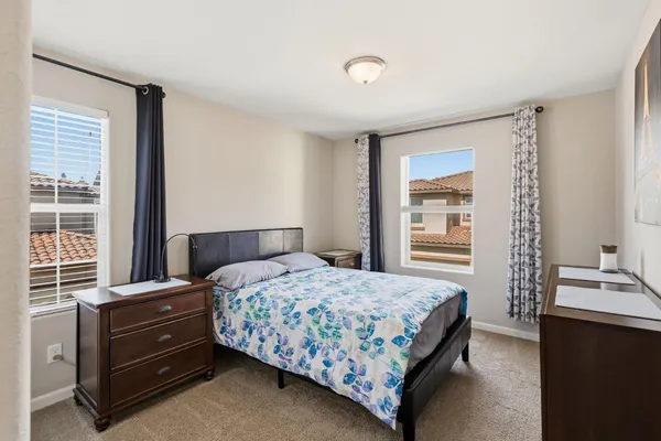 a bedroom with a bed and windows