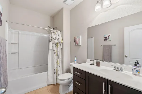a bathroom with a double vanity sink toilet mirror and shower