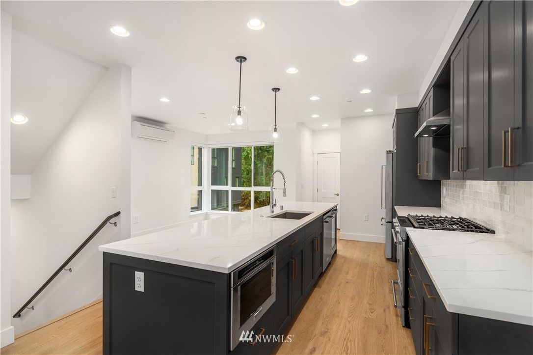 18517 96th Drive Northeast, Unit A Bothell, WA 98011 - Photo 3 of 31 a kitchen with stainless steel appliances granite countertop a sink a stove and a refrigerator