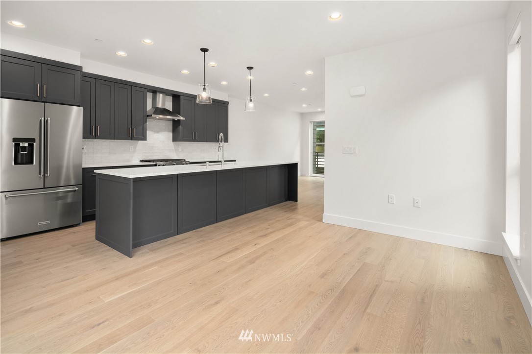 18517 96th Drive Northeast, Unit A Bothell, WA 98011 - Photo 5 of 31 a large kitchen with kitchen island a sink stainless steel appliances and cabinets