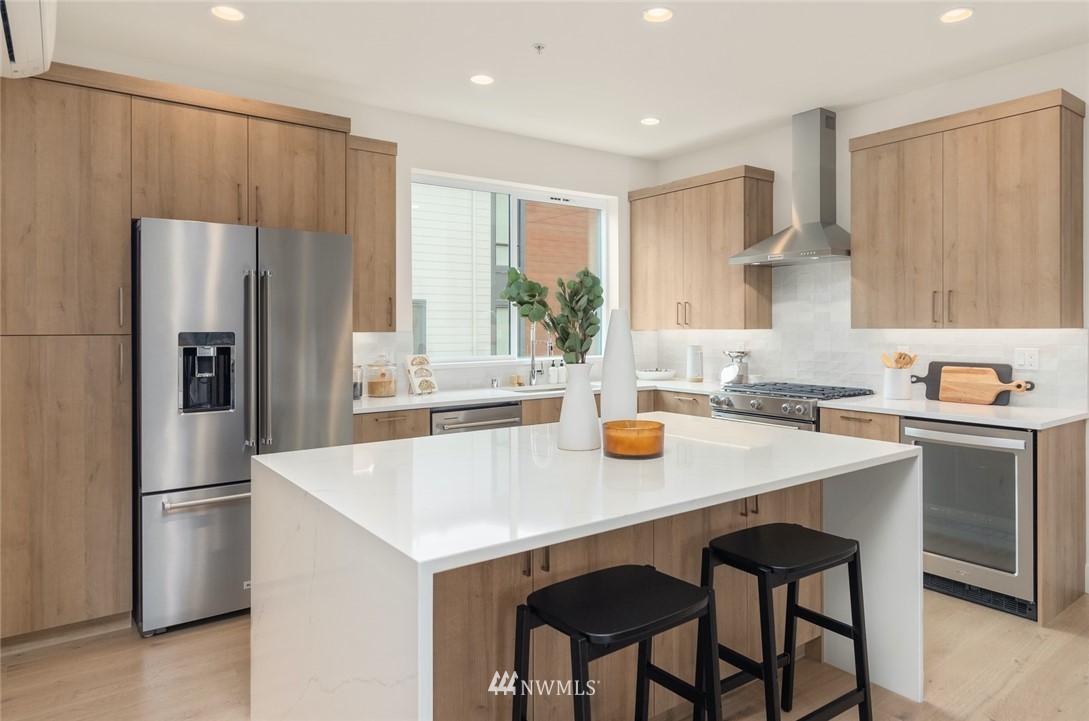 18517 96th Drive Northeast, Unit A Bothell, WA 98011 - Photo 9 of 31 a kitchen with a sink a refrigerator and a stove top oven with wooden floor