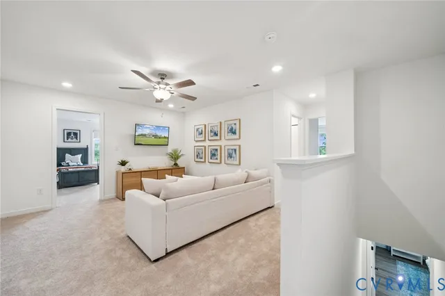 a living room with furniture and a ceiling fan