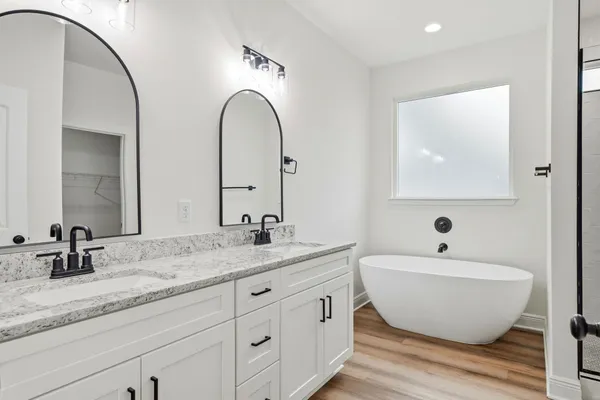 a bathroom with a granite countertop sink mirror and bathtub