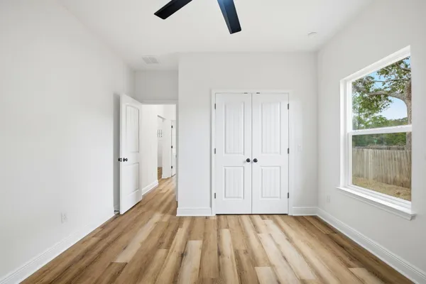 a view of an empty room with window and closet area