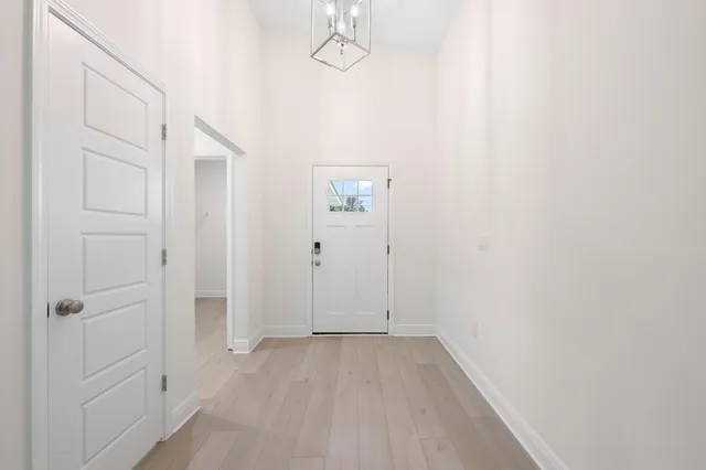 a view of an empty room with a fireplace and a chandelier fan