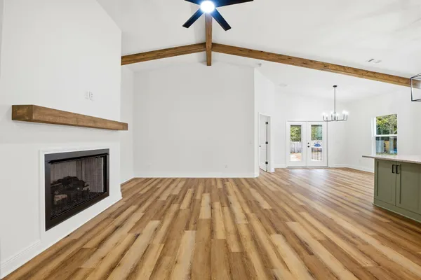 a view of empty room with wooden floor and fireplace