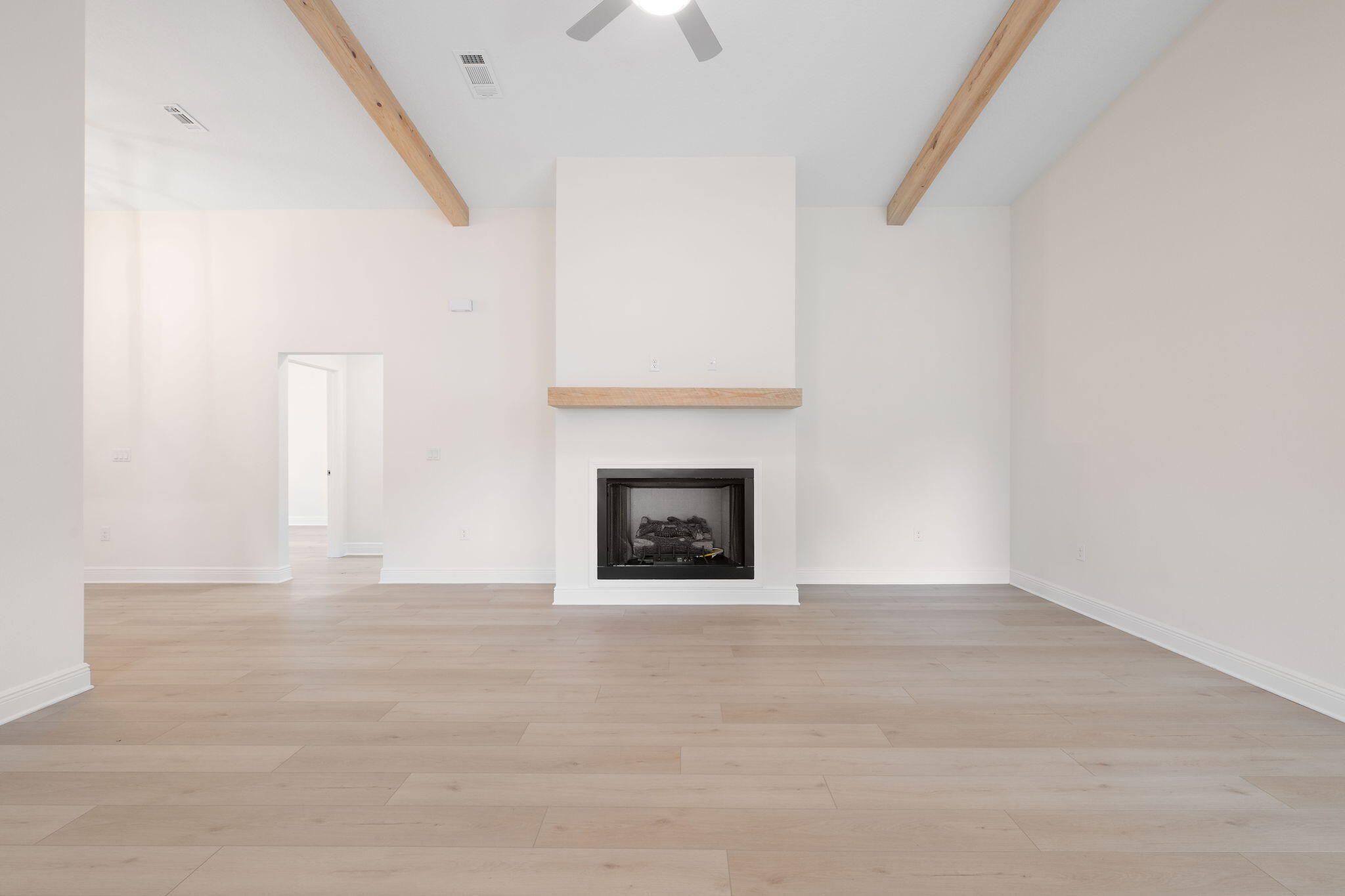 1854 Wheeler Road Gulf Breeze, FL 32563 - Photo 6 of 11 a view of an empty room with a fireplace and a chandelier fan