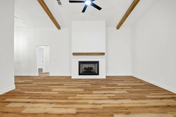 a view of an empty room with a fireplace and a window