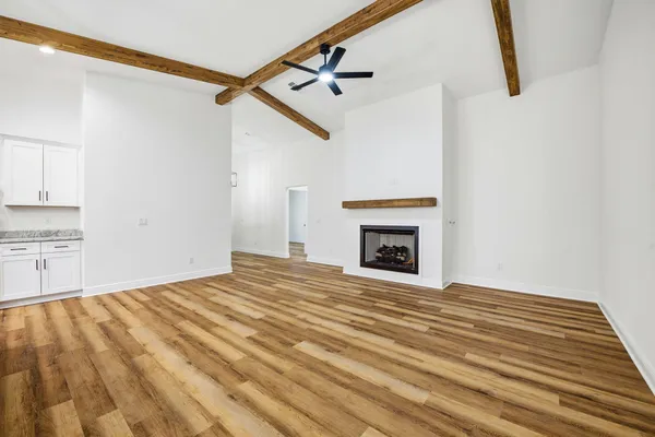 a view of empty room with wooden floor and fireplace
