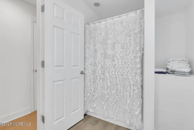 a bedroom with a large bed a flat tv screen and a dresser