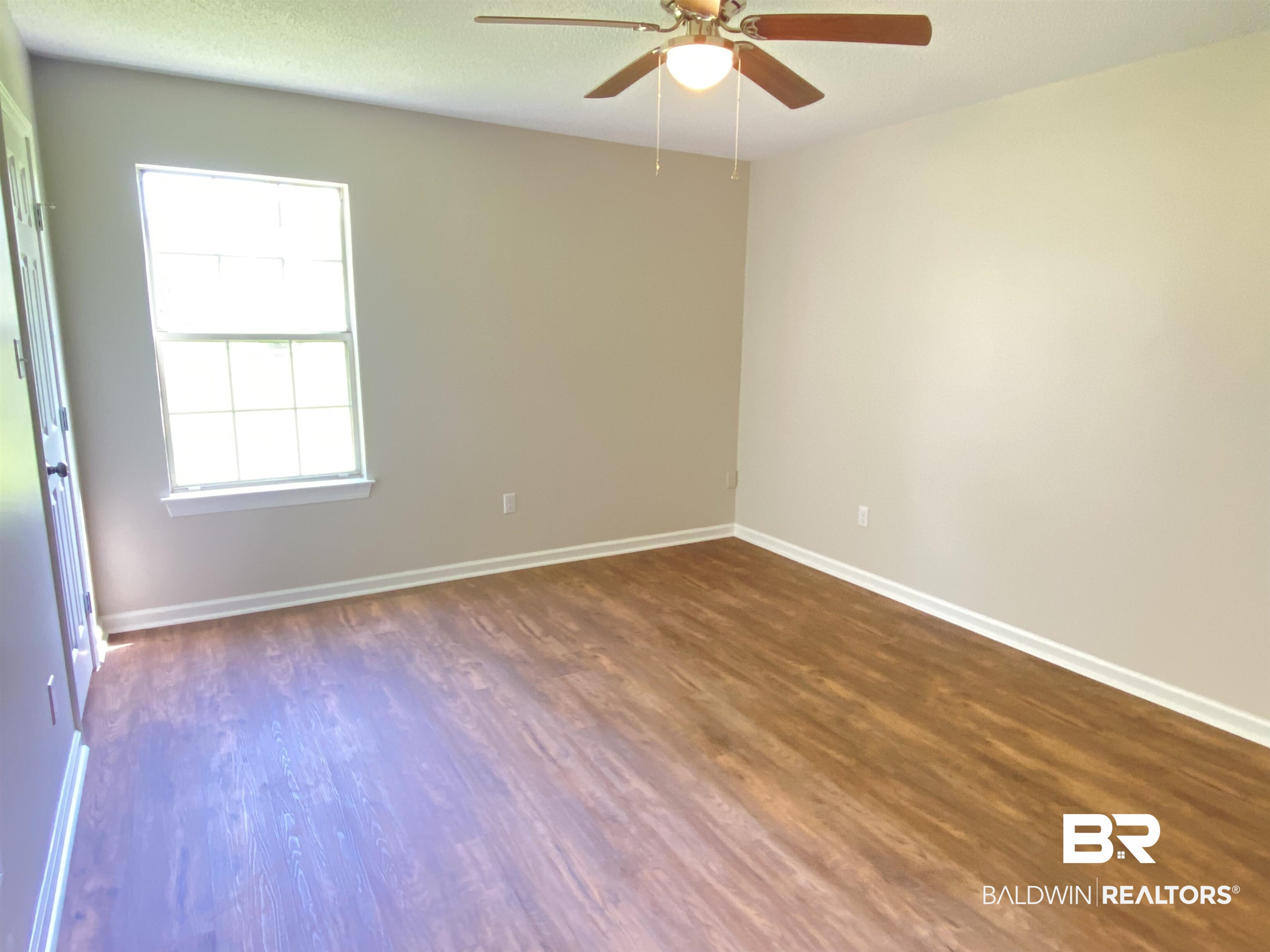 12150 Lee Bishop Road Irvington, AL 36544 - Photo 22 of 26 Spare room featuring baseboards, ceiling fan, and wood finished floors