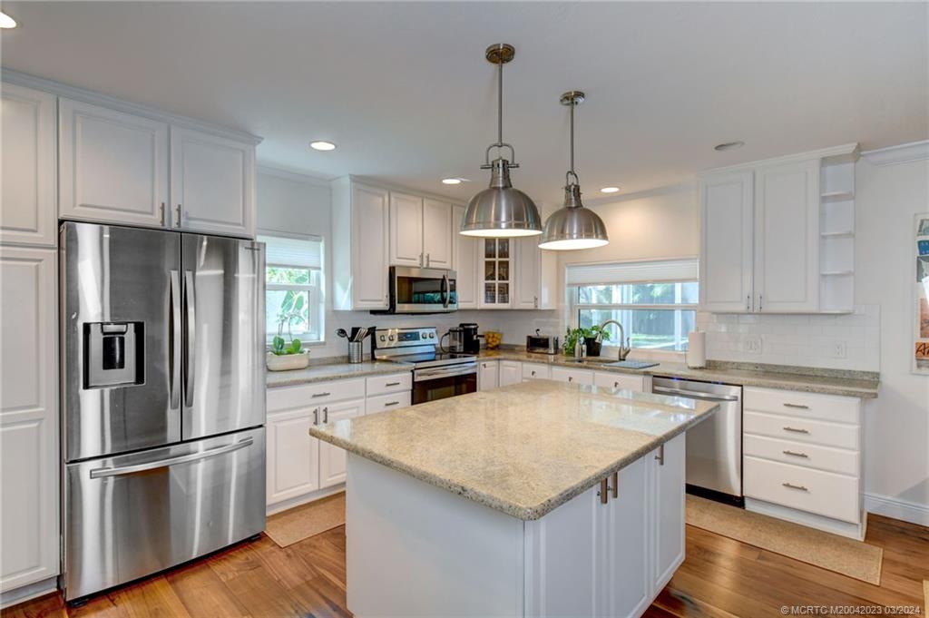 5 Banyan Road Stuart, FL 34996 - Photo 17 of 49 a kitchen with kitchen island granite countertop a center island stainless steel appliances and cabinets