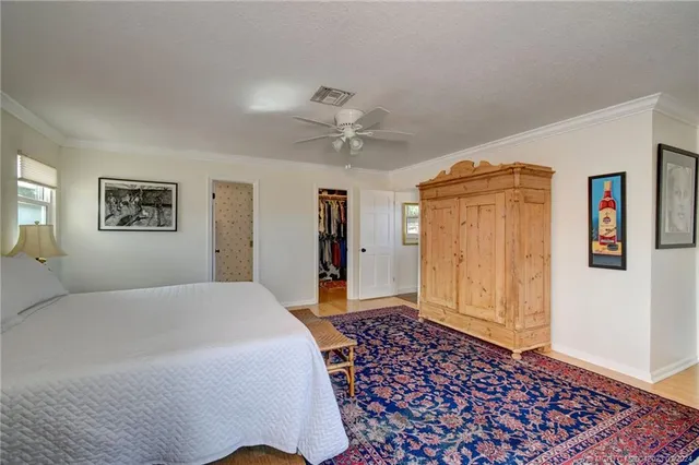 a spacious bedroom with a bed and a chandelier