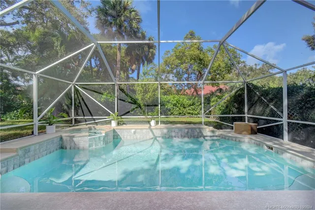 a view of a swimming pool with a patio and a yard