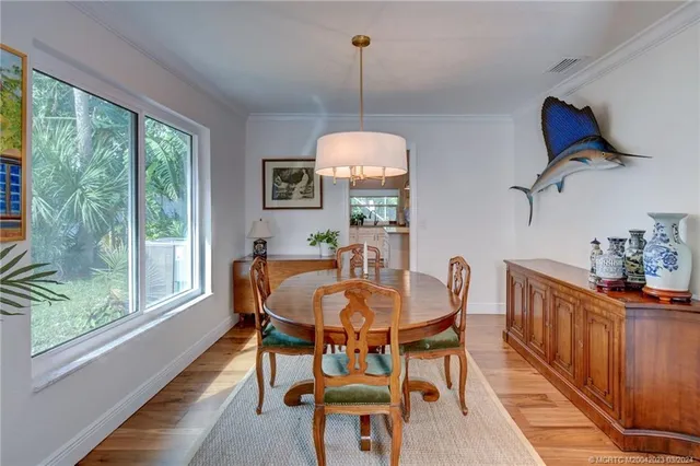 a dining room with furniture a chandelier and wooden floor