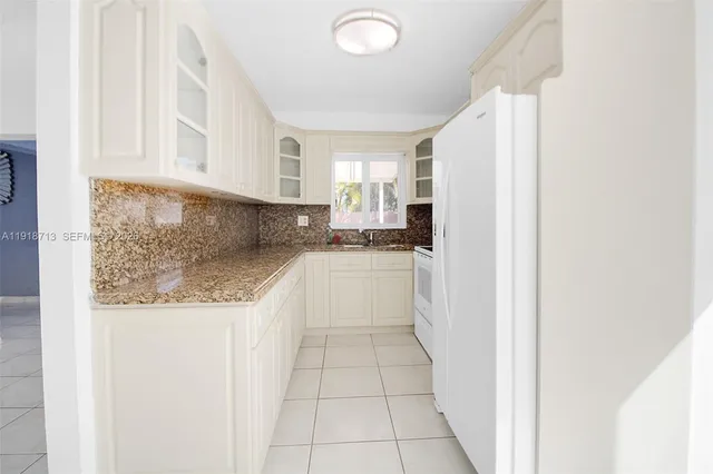 a white refrigerator freezer and a stove sitting inside of a kitchen