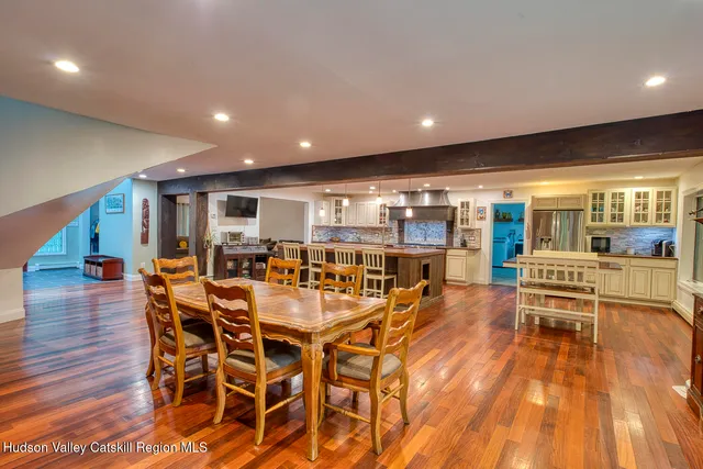 a view of a kitchen with kitchen island a large counter top space stainless steel appliances and cabinets