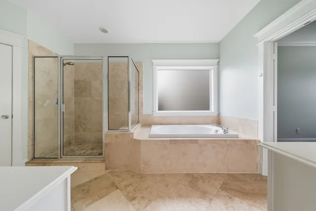 a spacious bathroom with a double vanity sink toilet mirror and bathtub