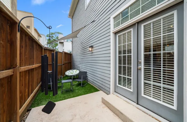 a view of a patio with table and chairs and wooden fence