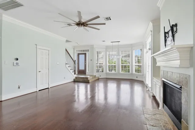 a view of an empty room with wooden floor fireplace and a window