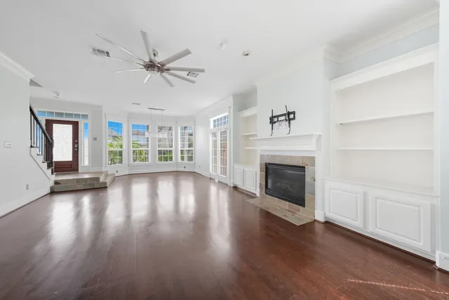 wooden floor fireplace and windows in an empty room