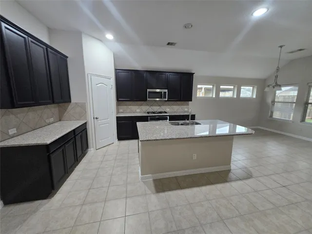 a kitchen with granite countertop a sink and a stove top oven